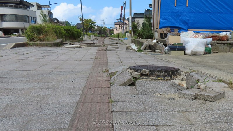 液状化で飛び出したマンホールと，側方流動で散乱した歩道のブロック