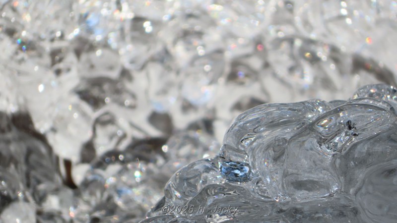 しぶきでできた氷が太陽光を受けて色付いている様子