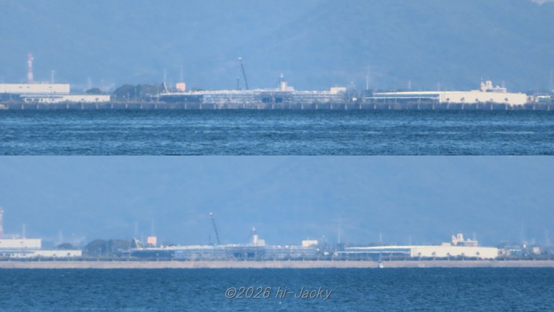 御津方向に見える建設中の工場，海沿いの木や防波堤が縦に伸びている